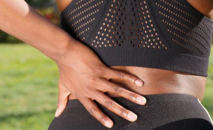 lady in sports clothes with hand on back